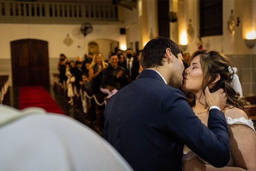 Beso de los novios en el altar en su ceremonia de boda en la iglesia, fotografía Esteban Lago